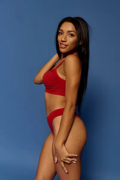 A beautiful young African American woman poses in stylish red lingerie, highlighting her confidence. — Stock Photo