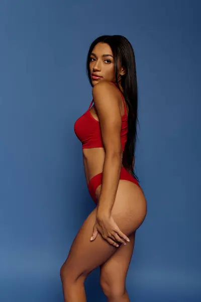 A stunning young African American woman poses elegantly in red underwear, celebrating beauty. — Stock Photo