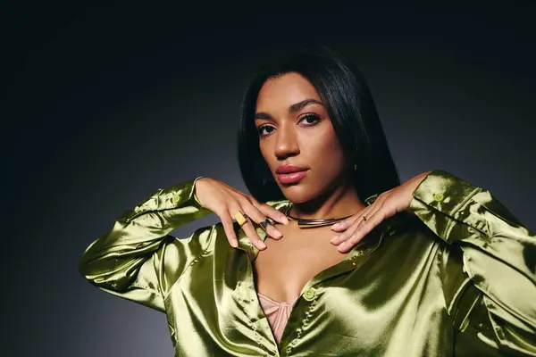 A stylish young Black woman confidently models a green silk shirt. — Stock Photo
