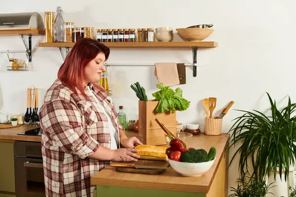 Inside a warm kitchen, a young plus size woman skillfully prepares fresh ingredients for a meal. — Stock Photo