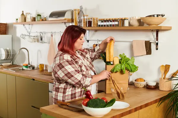 Young woman happily arranging fresh veggies in her kitchen for a healthy meal. — Stock Photo