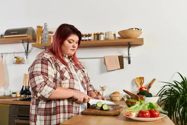 Young woman skillfully chops cucumbers for a delicious salad in a cozy kitchen. — Stock Photo