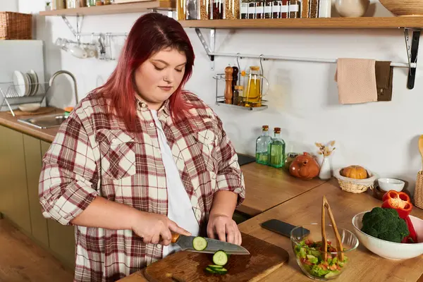 Young plus size woman skillfully prepares vegetables in a warm and inviting kitchen setting — Stock Photo
