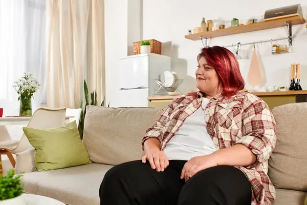 Young plus size woman relaxes comfortably on a sofa in her inviting living space — Stock Photo