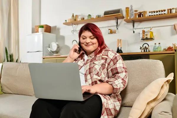 Young woman with vibrant hair engages in a video call while sitting on her couch. — Stock Photo