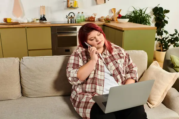 Plus size woman engages in a casual conversation while working on her laptop at home. — Stock Photo