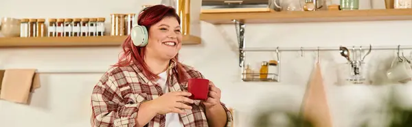 Jovem mulher com cabelo vibrante ri enquanto saboreia chá em seu ambiente acolhedor e elegante cozinha. — Fotografia de Stock