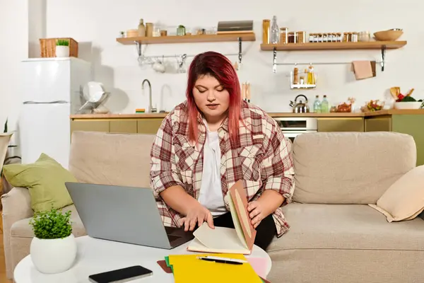 A beautiful plus size woman works creatively in her colorful, cozy home workspace. — Stock Photo