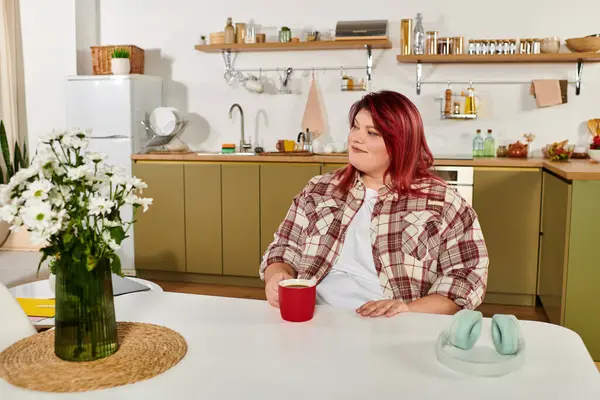 Luminoso e invitante ambiente cucina dove una donna plus size assapora il suo caffè del mattino. — Foto stock