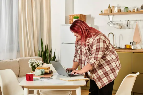 A young woman engages in her work at a stylish table surrounded by plants and decor. — Stock Photo