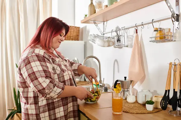 Young woman enjoys making a fresh salad in her bright, inviting kitchen filled with greens. — Stock Photo