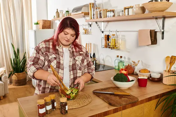 Bright and inviting kitchen showcases a plus size woman joyfully making a fresh salad. — Stock Photo