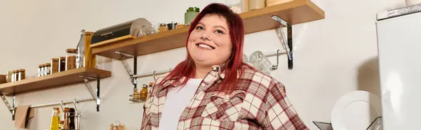 Young woman with vibrant personality stands happily in a warm kitchen filled with shelves. — Stock Photo