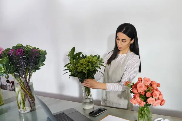 Brunette florist skillfully prepares fresh flower arrangements in her shop, showcasing her talent. — Stock Photo