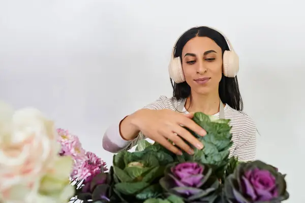 Una florista joven tiende meticulosamente a sus arreglos coloridos, mostrando su creatividad. - foto de stock