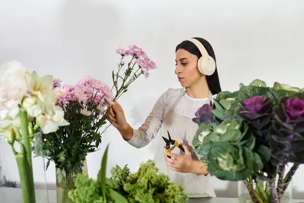 Una florista talentosa tiende a florecer mientras disfruta de su ambiente de trabajo.. - foto de stock