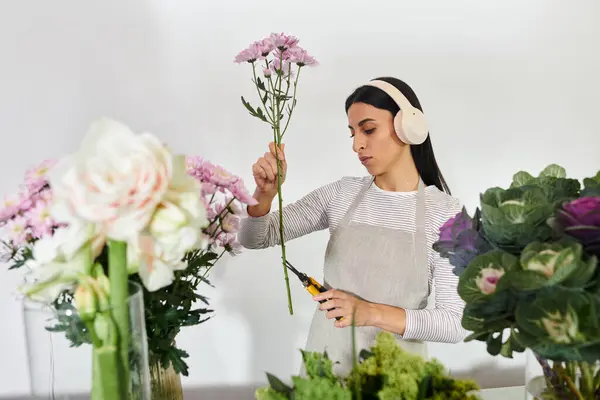 Une fleuriste habile taille soigneusement les fleurs, créant de beaux arrangements dans sa boutique. — Photo de stock