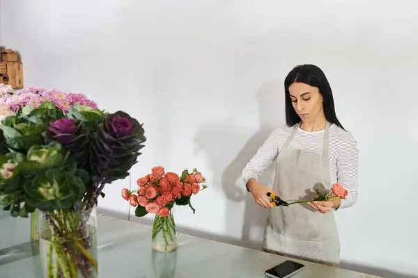 Une fleuriste dévouée organise des fleurs fraîches dans sa boutique dynamique, nourrissant sa petite entreprise. — Photo de stock