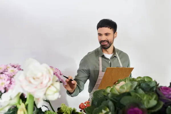 A skilled florist carefully selects flowers while creating stunning arrangements in his shop. — Stock Photo
