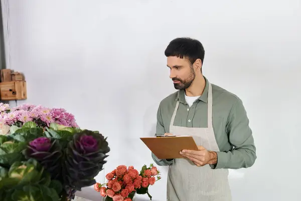 Bearded man meticulously arranges flowers while managing his small business with care. — Stock Photo