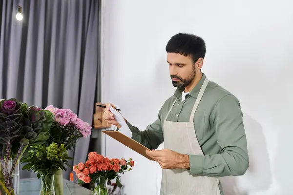 A skilled florist carefully manages orders while surrounded by colorful blooms and greenery. — Stock Photo