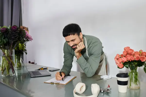 Un florista experto artesanía cuidadosamente arreglos florales mientras disfruta de su ambiente acogedor tienda. - foto de stock