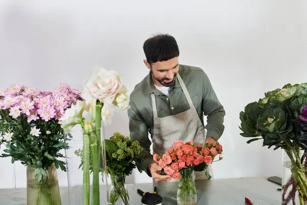 Un fleuriste habile crée un bouquet magnifique entre verdure luxuriante et fleurs, mettant en valeur la créativité. — Photo de stock