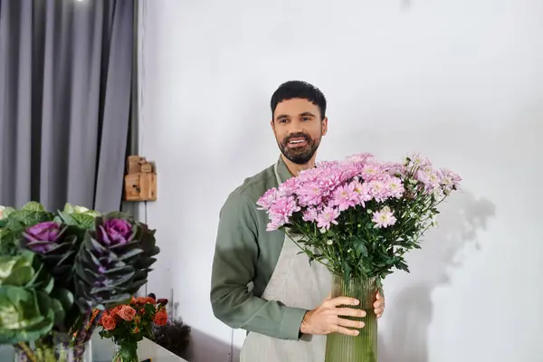 Un florista experto con barba organiza hermosas flores en un ambiente acogedor de la tienda. - foto de stock