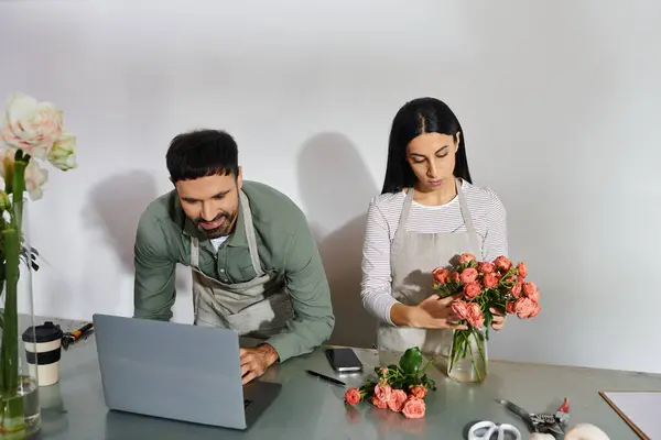 A couple works together lovingly arranging flowers while managing their small business. — Stock Photo