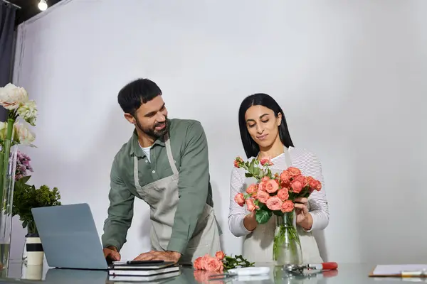 Un marido y una esposa organizan alegremente flores en su encantadora tienda de plantas, creando belleza diariamente.. - foto de stock