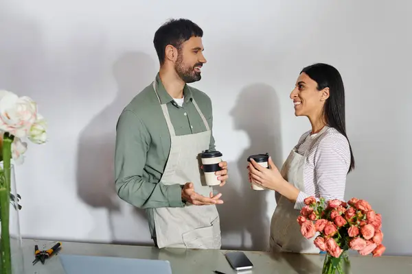 Un couple marié travaille ensemble dans leur boutique de fleurs, échangeant des idées et appréciant leur passion. — Photo de stock