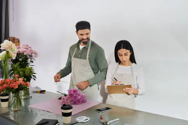 Un couple marié collabore dans leur boutique de fleurs, élaborant quotidiennement de superbes arrangements floraux. — Photo de stock