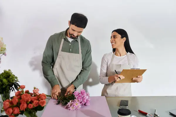 Fleuristes mariés collaborent à leur boutique, l'artisanat de superbes arrangements floraux avec soin. — Photo de stock