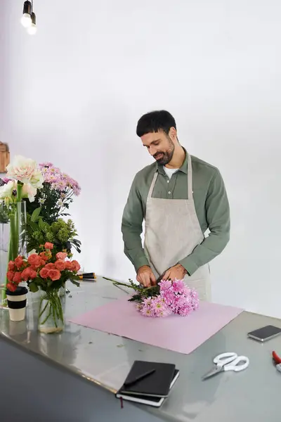 Un fleuriste habile prépare soigneusement des fleurs vibrantes dans sa boutique invitante. — Photo de stock