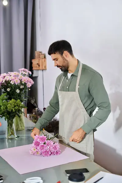 A skilled florist carefully arranges vibrant blooms in his cozy shop, showcasing his expertise. — Stock Photo