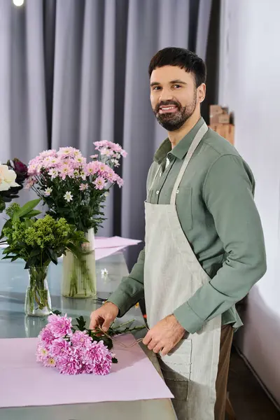 Un florista experto organiza cuidadosamente flores vibrantes en una acogedora tienda llena de vegetación. - foto de stock