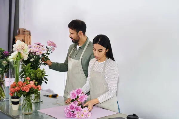 A married couple skillfully arranges fresh flowers in a warm and inviting florist shop. — Stock Photo