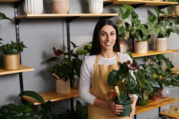 Una florista talentosa tiende a sus plantas coloridas, promoviendo la sostenibilidad y la belleza a diario. - foto de stock
