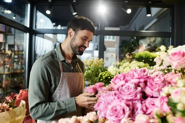 A bearded florist picks stunning blooms in his lovely shop, showing his creativity and passion. — Stock Photo