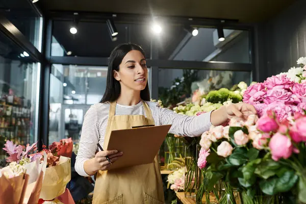 A skilled florist tends to blooming flowers while managing her small business creatively. — Stock Photo