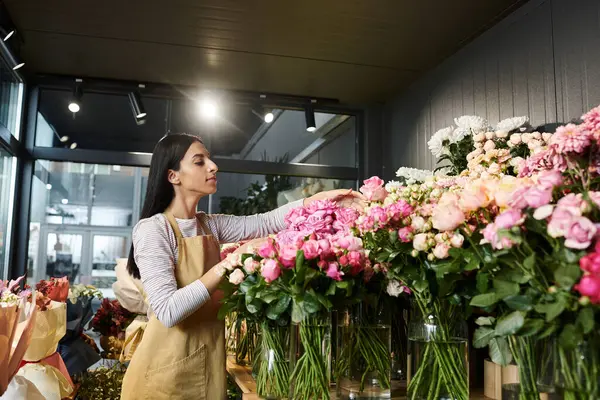 Una florista arregla flores vibrantes en su acogedora tienda, mostrando su pasión. - foto de stock