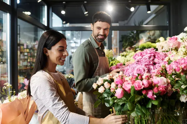Married couple work together in their florist shop, arranging beautiful flowers and plants. — Stock Photo