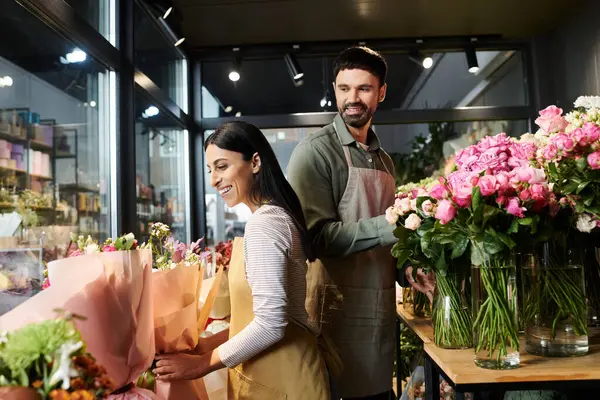 Couple collaborates joyfully on stunning flower arrangements inside their charming shop. — Stock Photo