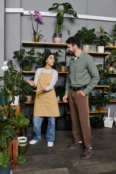 Florist helps a male client explore vibrant plants in a charming flower shop setting. — Stock Photo