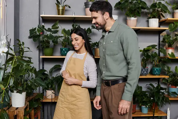A knowledgeable florist assists a client in selecting beautiful plants at their shop. — Stock Photo