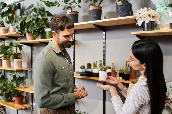 A skilled florist consults with a male client, sharing insights about potted plants. — Stock Photo