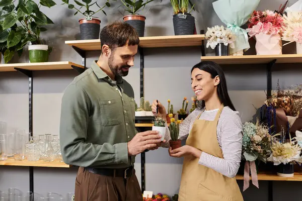 Um florista compartilha conselhos de especialistas com um cliente em uma vibrante loja de flores cheia de plantas. — Fotografia de Stock