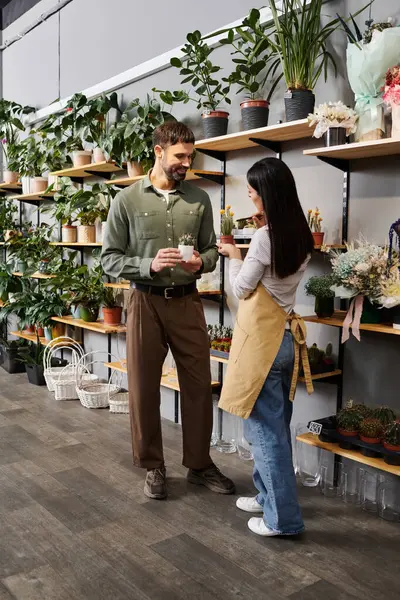 Florist engages with a male client, guiding him through a variety of lush green plants. — Stock Photo