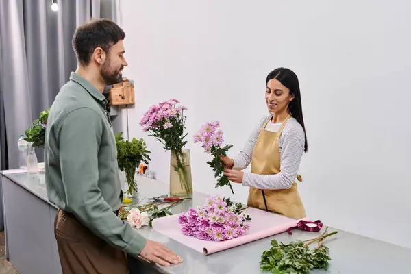 Fleuriste dédié s'engage avec le client masculin, habilement créer un beau bouquet ensemble. — Photo de stock