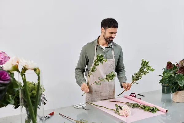 A skilled florist creates beautiful displays in his inviting shop, among lush greenery. — Stock Photo